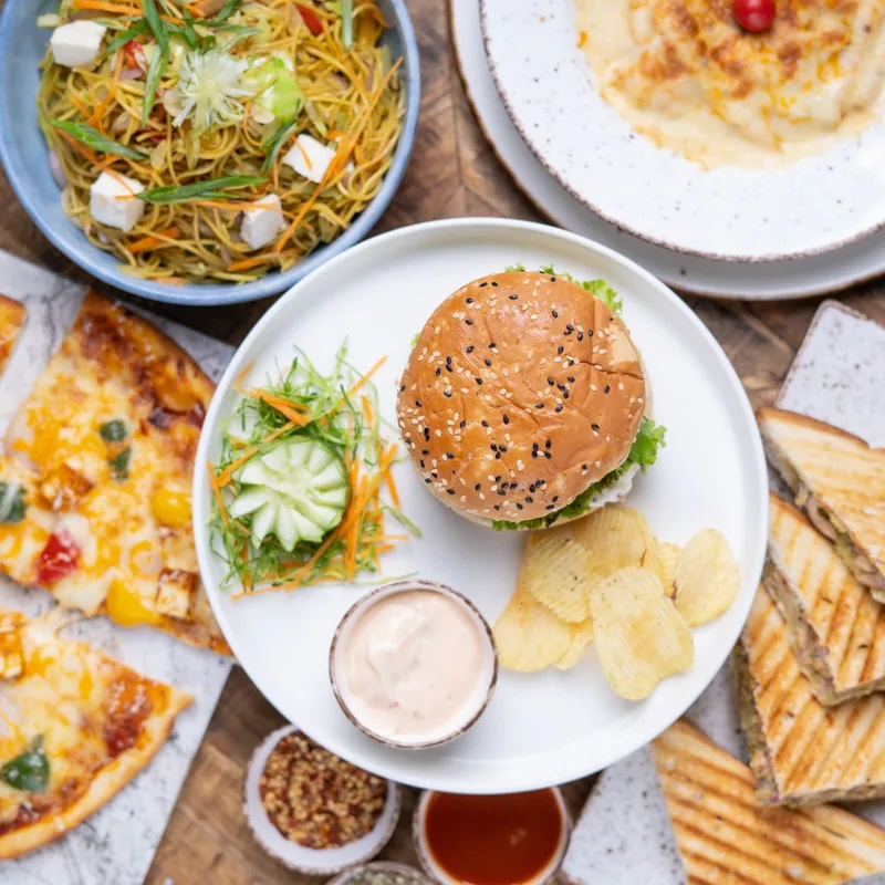 A spread of café snacks including burgers, sandwiches and pizza